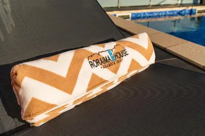 a towel sitting on a table next to a swimming pool at Roraima House - Private Pool & Garden in Calheta