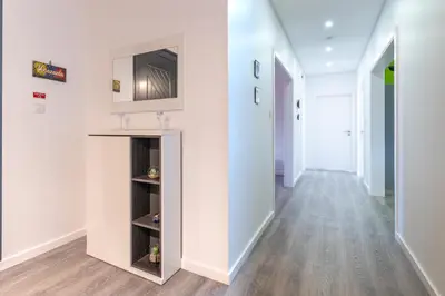 a hallway with white walls and a television on a wall at Roraima House - Private Pool & Garden in Calheta