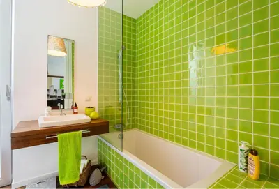 a green tiled bathroom with a tub and a sink at Villa Mar Garajau in Caniço