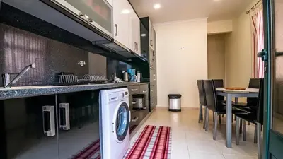 a kitchen with a washing machine and a dining room at Seaside House in Estreito in Estreito da Calheta