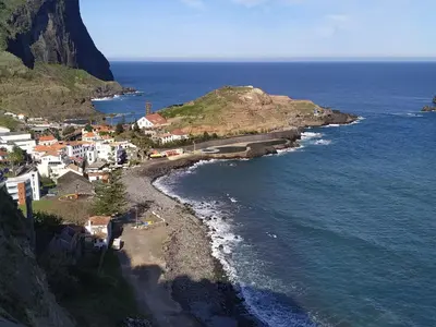 an aerial view of a small town on a hill next to the ocean at Souza Beach Apartment - Porto da Cruz - Studio & Suite in Porto da Cruz