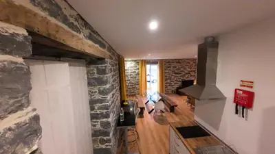 a living room with a stone wall at Souza Beach Apartment - Porto da Cruz - Studio & Suite in Porto da Cruz
