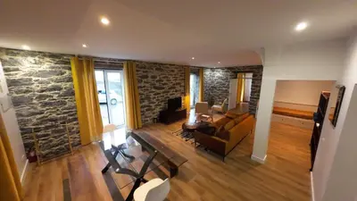 a living room with a stone wall at Souza Beach Apartment - Porto da Cruz - Studio & Suite in Porto da Cruz