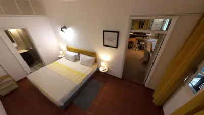 a small bedroom with a bed and a hallway at Souza Beach Apartment - Porto da Cruz - Studio & Suite in Porto da Cruz