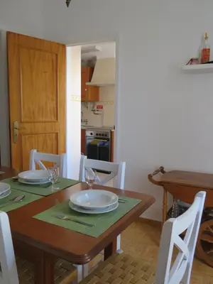 a dining room with a wooden table with white plates on it at Casa do Quintalão in Raposeira