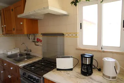 a kitchen with a stove and a sink and a window at Casa do Quintalão in Raposeira
