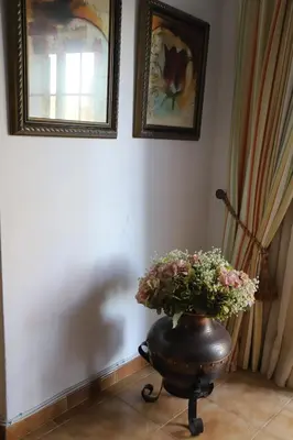 a vase with flowers on a table in a room at Casa do Quintalão in Raposeira