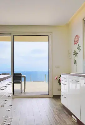 a kitchen with a sliding glass door with a view of the ocean at Holiday Apartment Ocean View in Ribeira Brava