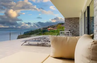 a couch on a balcony with a view of the ocean at Holiday Apartment Ocean View in Ribeira Brava