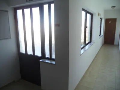 a hallway with a door and windows in a building at Quartos Maria Clara in Sagres