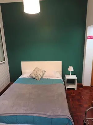 a bedroom with a bed with a green wall at FX Carvalhal in Funchal