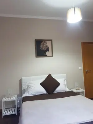 a bedroom with a white bed with a black pillow at FX Carvalhal in Funchal