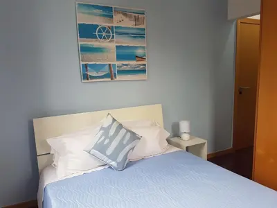 a bed with a blue and white pillow on it at FX Carvalhal in Funchal