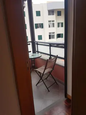 a balcony with a chair and a table and a building at FX Carvalhal in Funchal