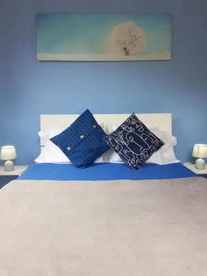 a bed with two blue and white pillows on it at FX Carvalhal in Funchal