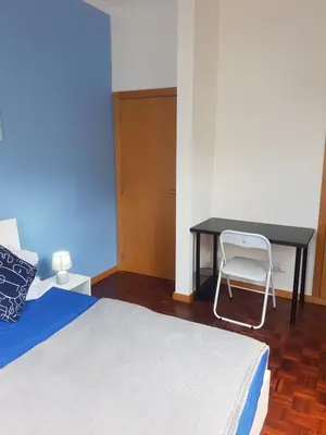 a bedroom with a desk and a bed with a chair at FX Carvalhal in Funchal