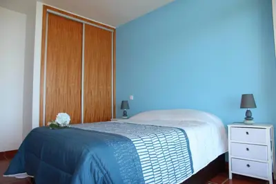 a bedroom with a bed with a blue wall at Apartamento MAR AZUL in Calheta