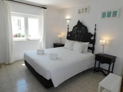 a bedroom with a large bed with two shoes on it at Luz Beach Center in Luz