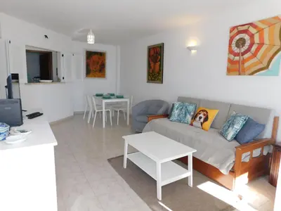 a living room with a couch and a tv at Luz Beach Center in Luz