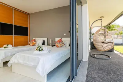 a bedroom with two beds and a glass wall at Casa Mia, a Dream Spot With Heated Pool in Arco da Calheta
