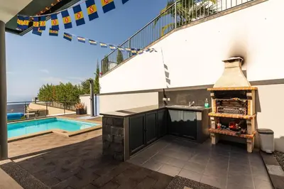 a patio with a grill and a swimming pool at Casa Mia, a Dream Spot With Heated Pool in Arco da Calheta