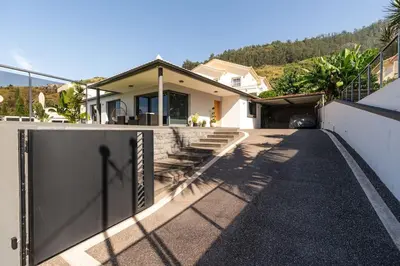 a house with a gate on the side of it at Casa Mia, a Dream Spot With Heated Pool in Arco da Calheta