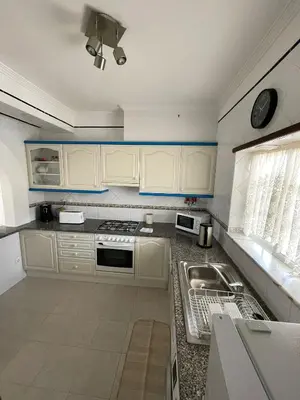 a kitchen with white cabinets and a sink at Amarguinha in Burgau