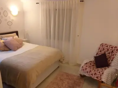 a bedroom with a bed and a chair at Amarguinha in Burgau