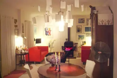 a living room with a table and a red couch at Raposeira de São João, the feeling of peace, space and quiet, Whole villa is yours in Fajã da Ovelha