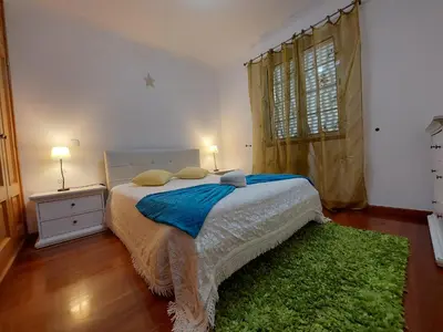 a bedroom with a bed and a green rug at Madeira Island Villa Oceane Ribeira Brava in Ribeira Brava