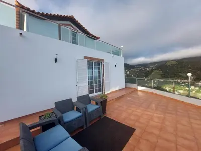 a balcony with couches and a view of a mountain at Madeira Island Villa Oceane Ribeira Brava in Ribeira Brava