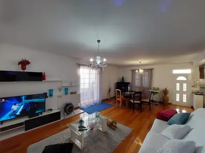 a living room with a white couch and a tv at Madeira Island Villa Oceane Ribeira Brava in Ribeira Brava