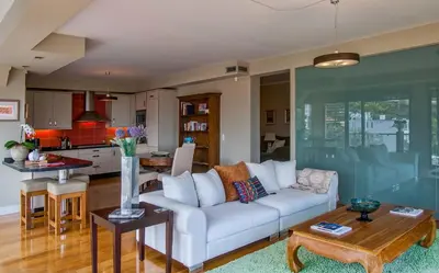 a living room with a white couch and a kitchen at Number 15 Ocean & City View Villas in Funchal