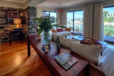 a living room with a vase of flowers on a table at Number 15 Ocean & City View Villas in Funchal