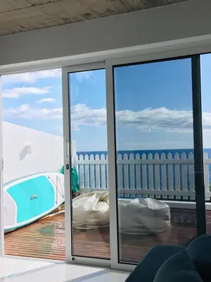 a room with a sliding glass door with a view of the ocean at CASA DO MAR in Jardim do Mar