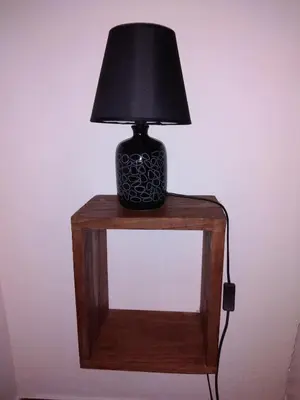 a black lamp sitting on top of a wooden table at Casa dos Valentes in Santo Espírito