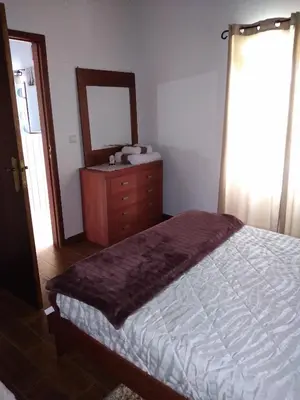 a bedroom with a bed and a dresser and a mirror at Casa dos Valentes in Santo Espírito