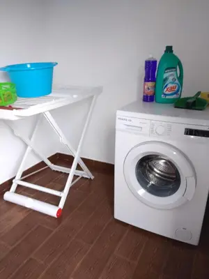 a washing machine with a white cart next to it at Casa dos Valentes in Santo Espírito