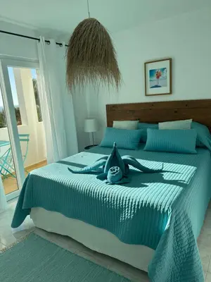 a woman laying on a bed in a bedroom at Muramaris in Salema