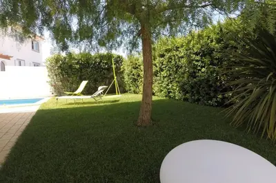 a yard with a hammock and a tree and a pool at Muramaris in Salema