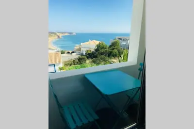 a balcony with a blue chair and a view of the ocean at Muramaris in Salema