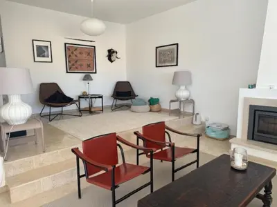a living room with chairs and a table and a fireplace at Muramaris in Salema