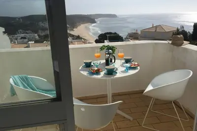 a table on a balcony with a view of the ocean at Muramaris in Salema