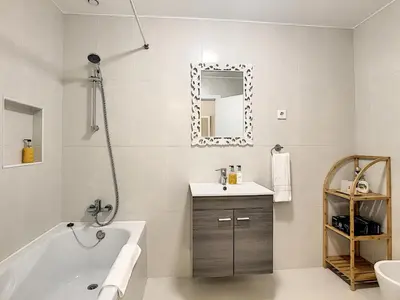 a bathroom with a tub and a sink and a mirror at Apartment Lotus by LovelyStay in Funchal