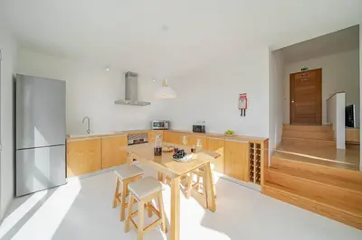 a kitchen with a wooden table and chairs in a room at Casas da Vargem shared swimming pool by An Island Apart in Ponta do Sol