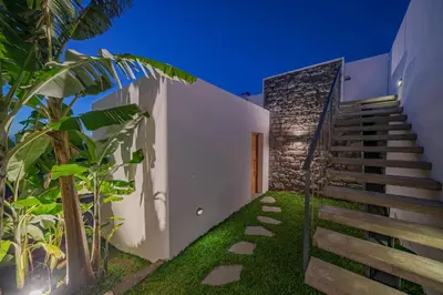 a staircase leading up to a white house with green plants at Casas da Vargem shared swimming pool by An Island Apart in Ponta do Sol