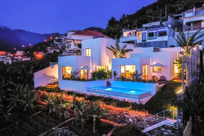 a villa with a swimming pool at night at Casas da Vargem shared swimming pool by An Island Apart in Ponta do Sol