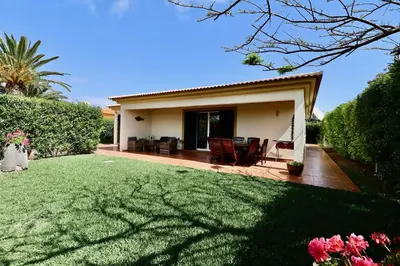 a small house with a lawn in front of it at Casa das Ondas by AnaLodges in Porto Santo