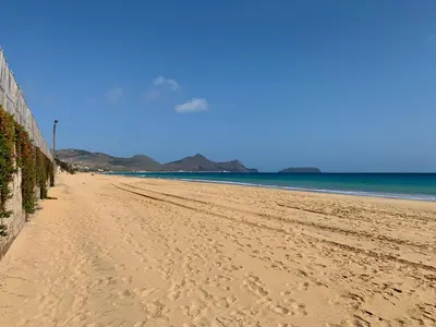 a beach with footprints in the sand and the ocean at Casa das Ondas by AnaLodges in Porto Santo