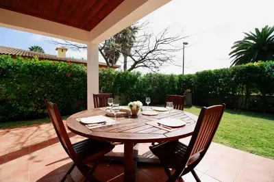 a wooden table and chairs on a patio at Casa das Ondas by AnaLodges in Porto Santo